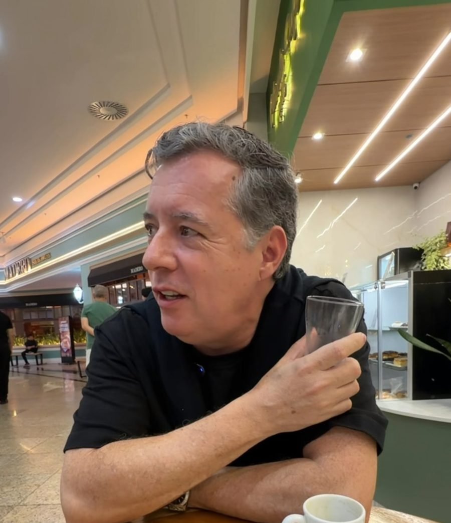 Leopoldo Arias sentado em um café, segurando um copo