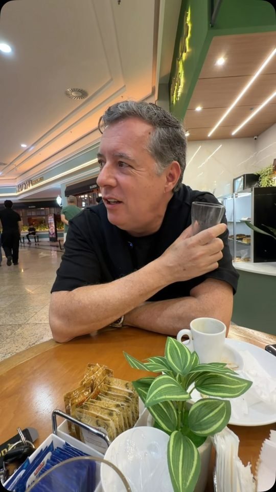 Frame de vídeo do Leopoldo segurando um copo